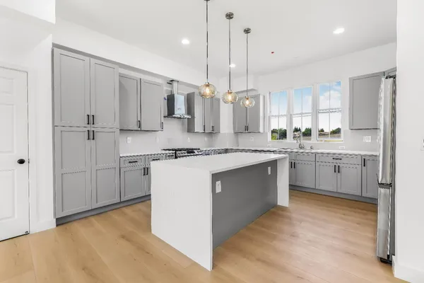 a kitchen with stainless steel appliances sink stove and cabinets