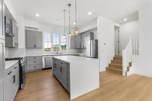 a kitchen with stainless steel appliances granite countertop a sink a stove and a refrigerator