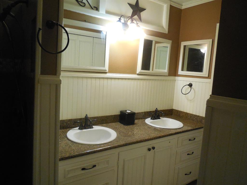 609 West Main Street Ranger, TX 76470 - Photo 7 of 29 a bathroom with a granite countertop sink and a mirror