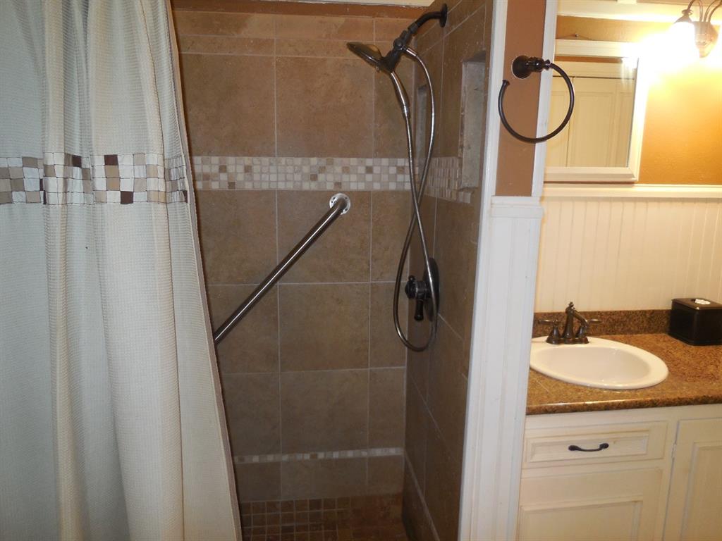 609 West Main Street Ranger, TX 76470 - Photo 8 of 29 a bathroom with a sink vanity mirror and shower