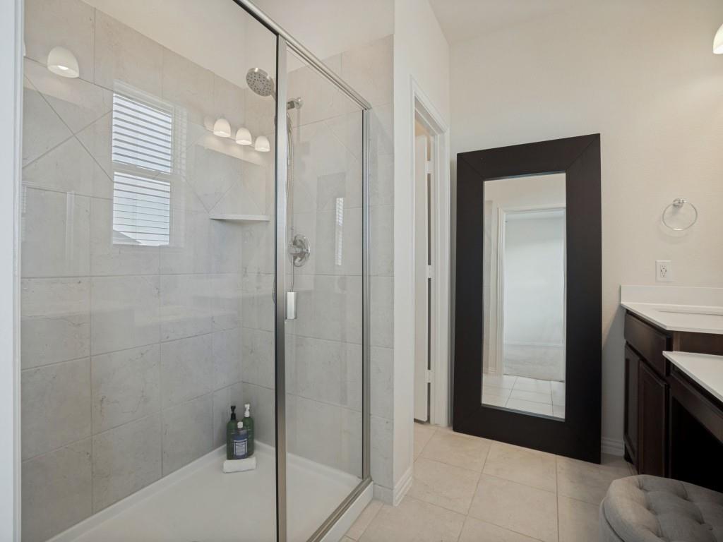 145 Prairie Trail Rhome, TX 76078 - Photo 21 of 25 Tile-surround shower with glass enclosure, built-in shelving, and rain showerhead