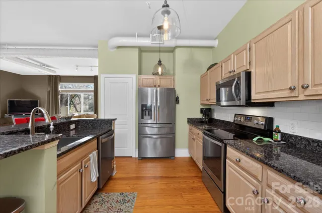 a kitchen with stainless steel appliances granite countertop a sink stove and refrigerator