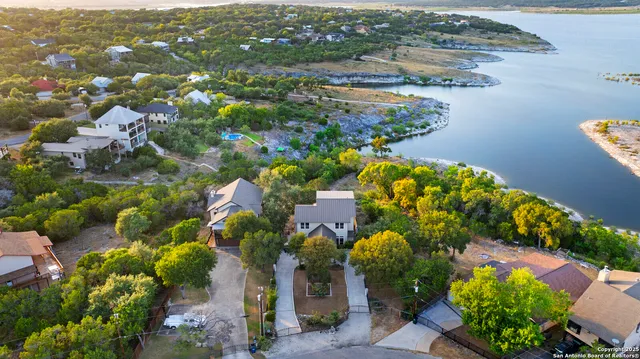 an aerial view of a house with a yard and lake view