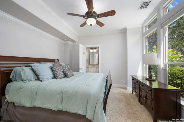 a view of a dining room and livingroom with furniture wooden floor a rug a painting and a chandelier