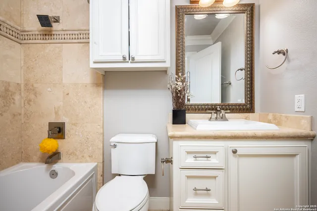 a bathroom with a granite countertop sink a large mirror and a bathtub