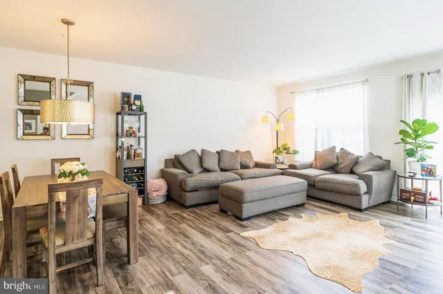 a living room with furniture a flat screen tv and a window