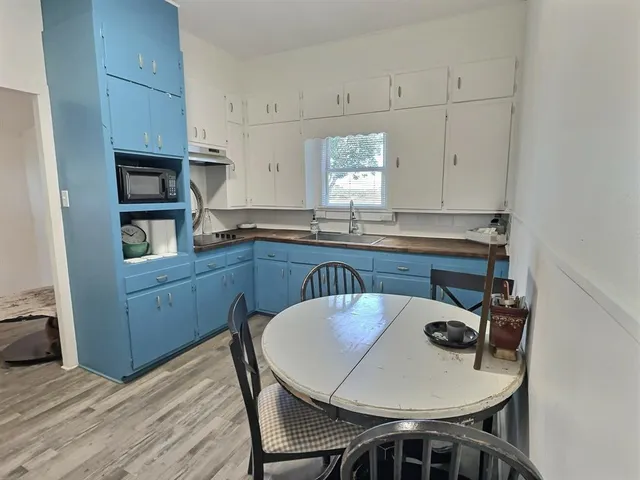 a kitchen with granite countertop a dining table chairs and cabinets