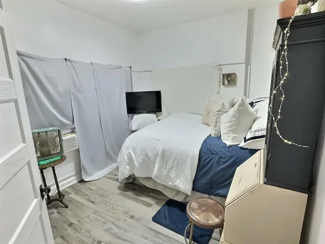 a bedroom with a bed and a mirror on the dresser