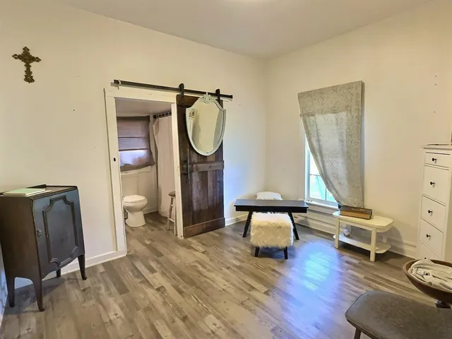 a living room with furniture a window and wooden floor