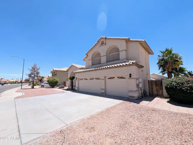 an empty room with wooden floor chandelier and windows