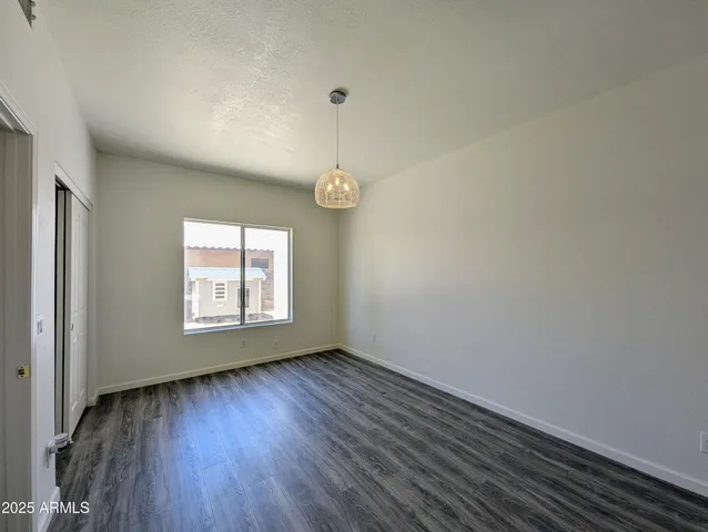 a view of a room with wooden floor and a ceiling fan