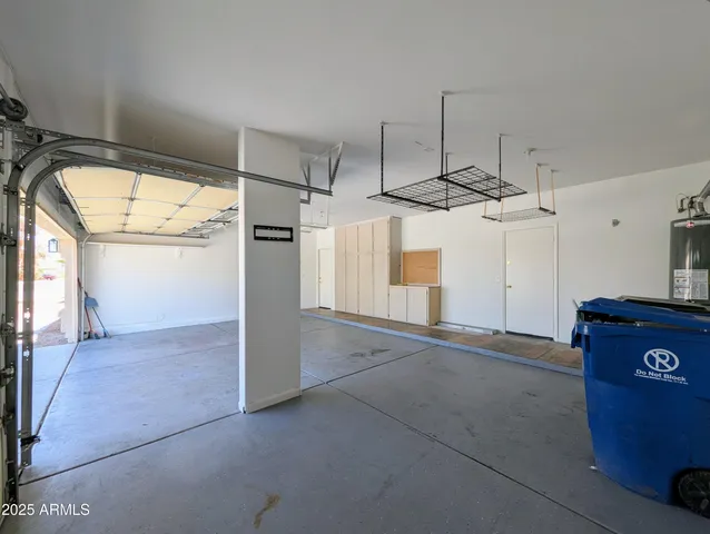 an empty room with wooden floor chandelier fan and windows