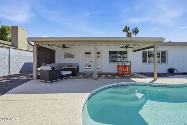 a dining hall with stainless steel appliances kitchen island granite countertop a table and chairs in it