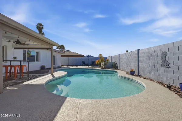a view of a house with swimming pool and a chairs
