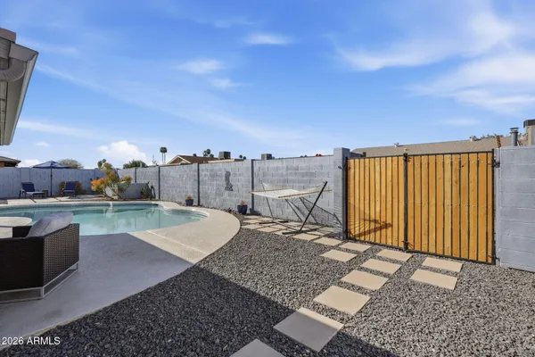 a view of a patio with table and chairs under an umbrella