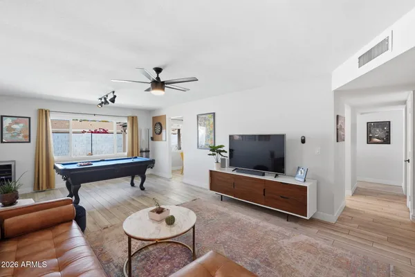 a living room with furniture a rug and a ceiling fan