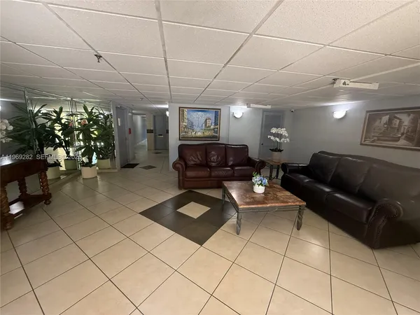 a living room with furniture a couch and a potted plant