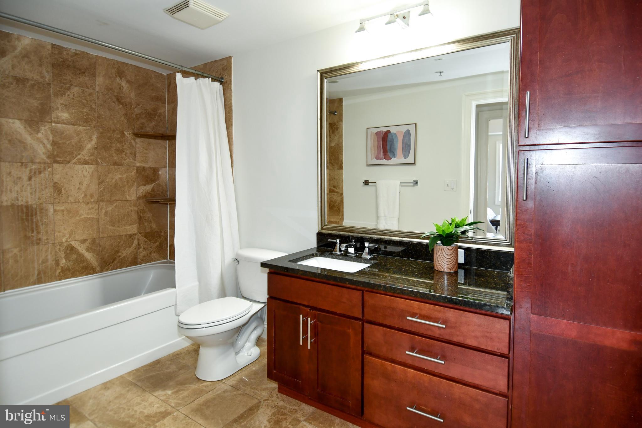 6301 Edsall Road, Unit 115 Alexandria, VA 22312 - Photo 17 of 37 a bathroom with a granite countertop sink toilet mirror and bathtub