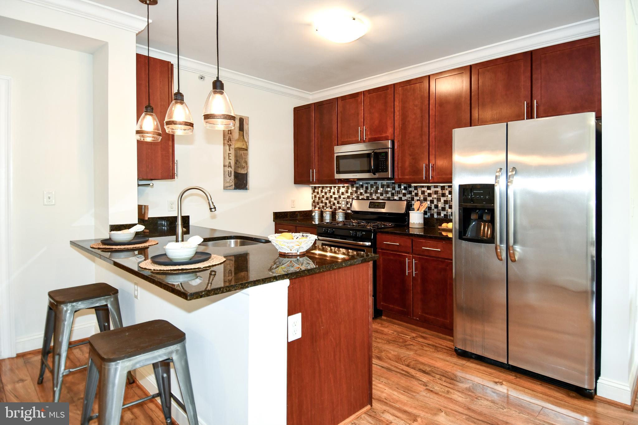 6301 Edsall Road, Unit 115 Alexandria, VA 22312 - Photo 3 of 37 a kitchen with stainless steel appliances granite countertop a sink refrigerator and microwave