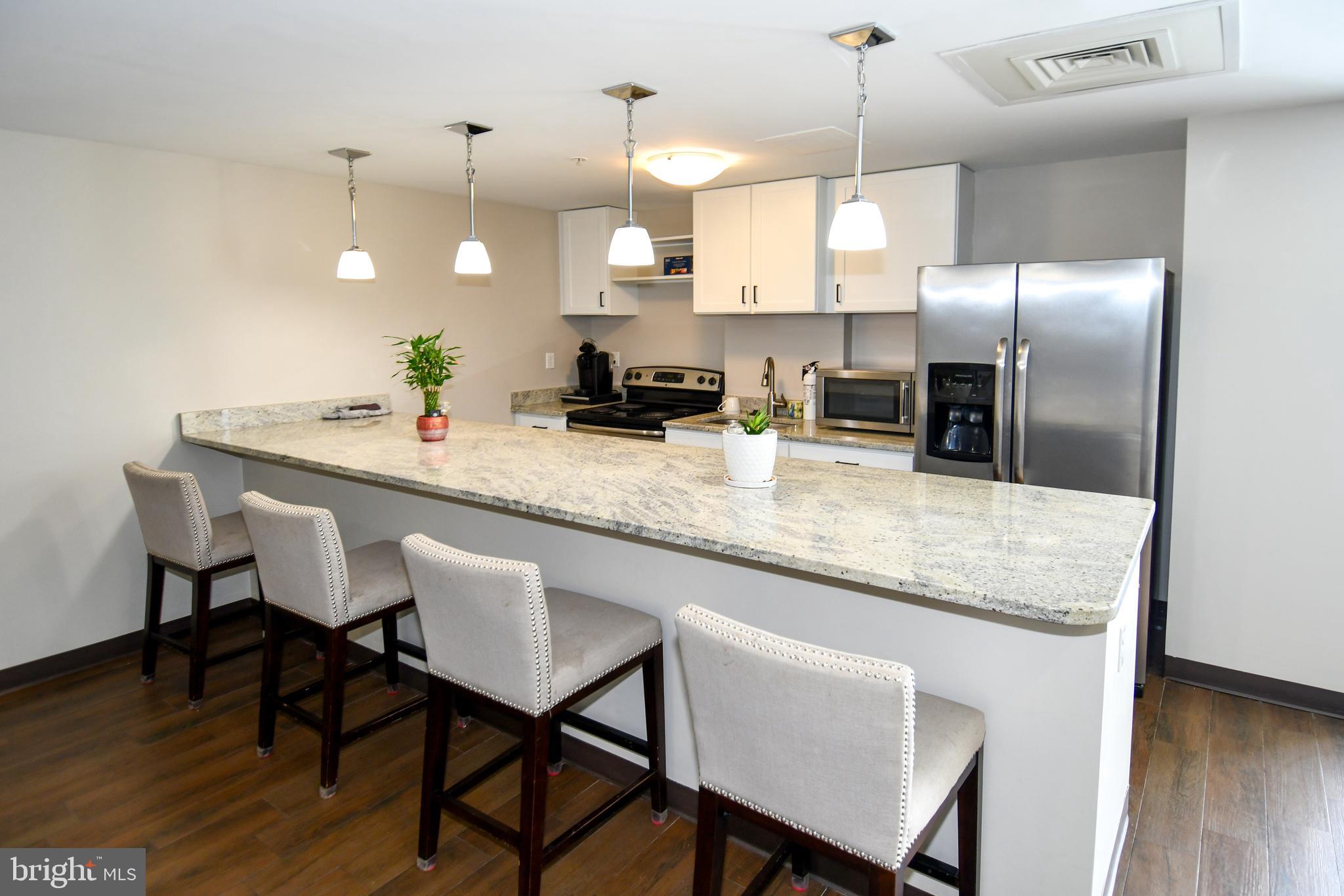 6301 Edsall Road, Unit 115 Alexandria, VA 22312 - Photo 33 of 37 a kitchen with granite countertop white cabinets stainless steel appliances and dining table