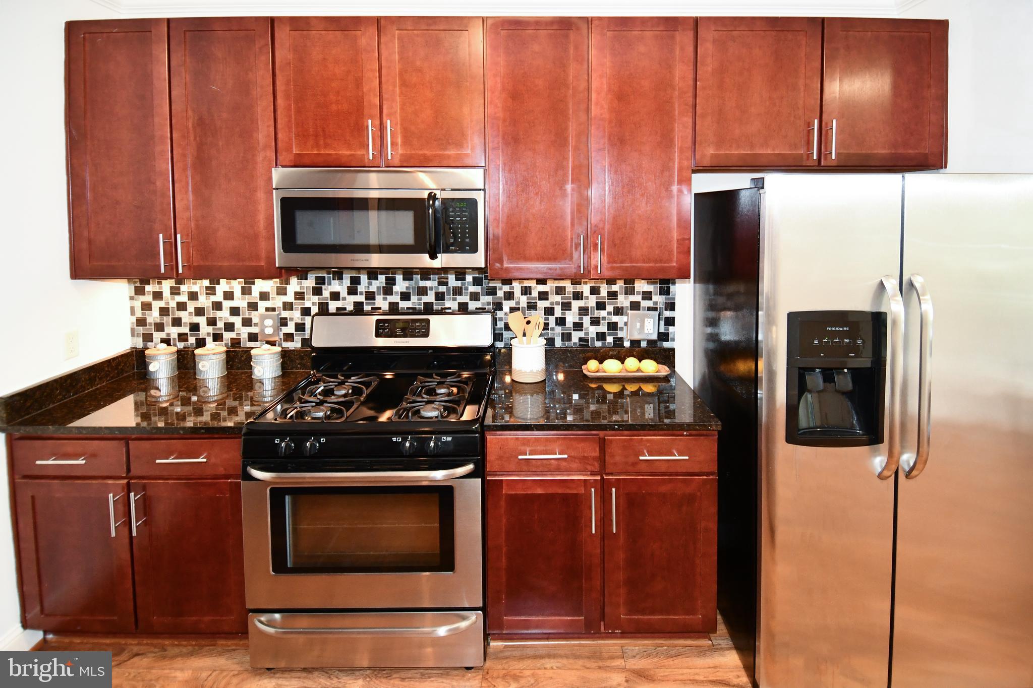 6301 Edsall Road, Unit 115 Alexandria, VA 22312 - Photo 4 of 37 a kitchen with stainless steel appliances wooden cabinets and stove