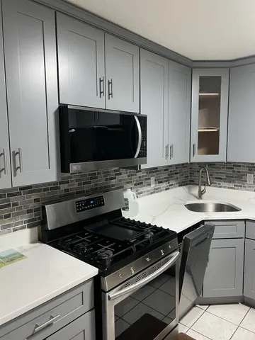 a kitchen with granite countertop a sink and a stove top oven