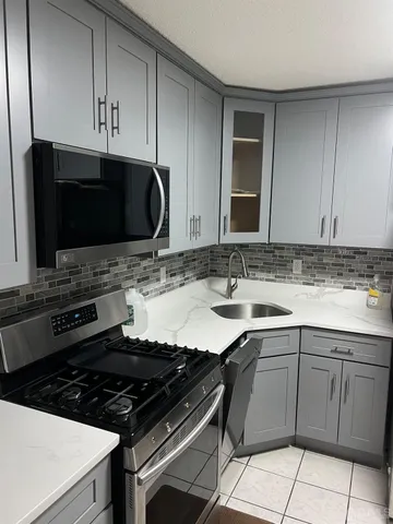a kitchen with granite countertop a sink and a stove top oven