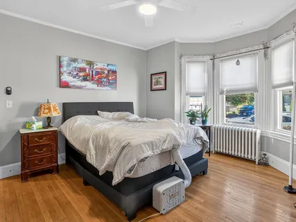 a bedroom with furniture and wooden floor