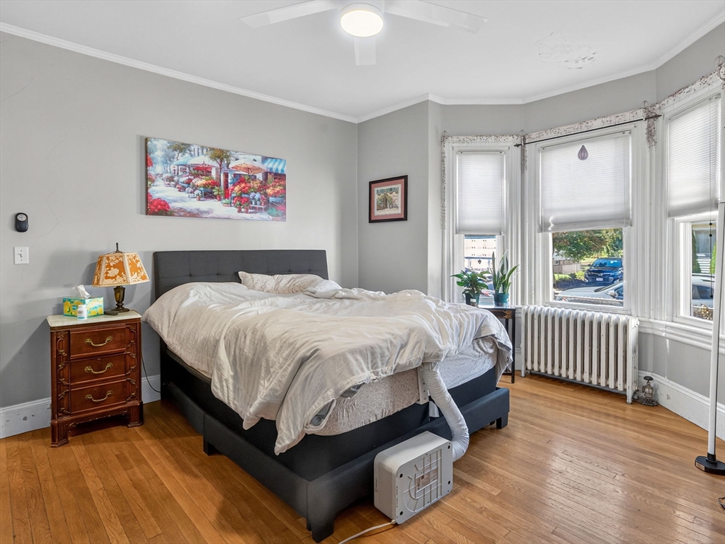 148 Beaver Street Boston, MA 02136 - Photo 16 of 25 a spacious bedroom with a bed a dresser and next to a window