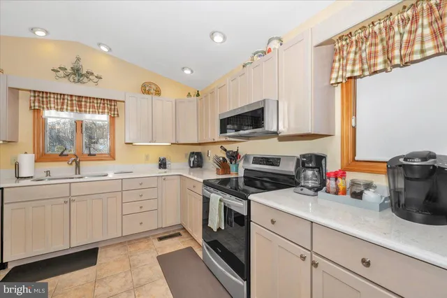 a kitchen with a sink a stove and cabinets