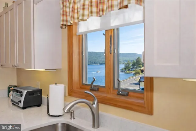 a kitchen with a sink and a view of living area