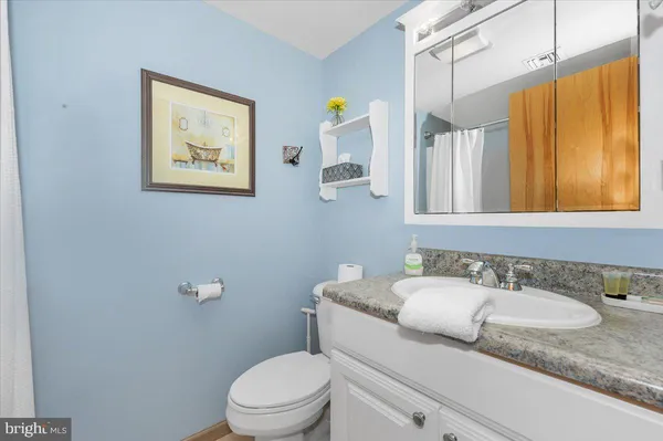 a bathroom with a granite countertop sink mirror vanity and toilet