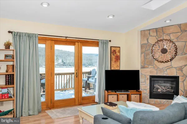 a living room with furniture a flat screen tv and a large window