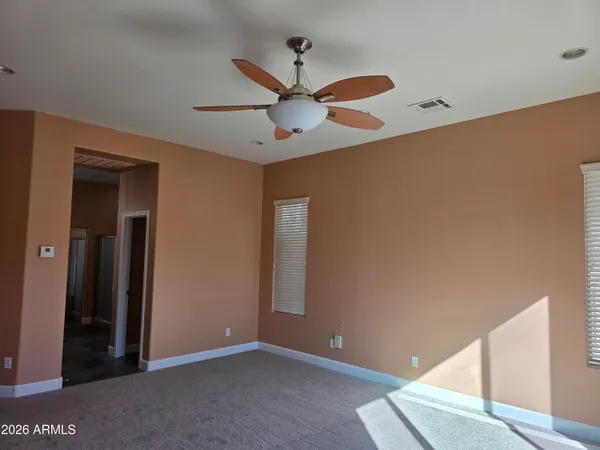 an empty room with a ceiling fan and window