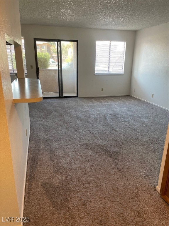 3717 Snorkel Circle, Unit C Las Vegas, NV 89108 - Photo 11 of 17 Unfurnished room with dark colored carpet, a textured ceiling, and a textured wall