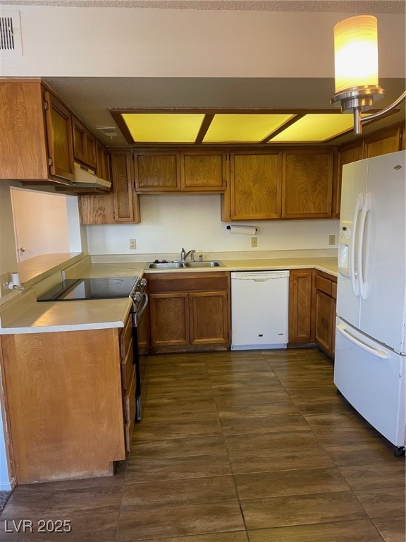 3717 Snorkel Circle, Unit C Las Vegas, NV 89108 - Photo 14 of 17 Kitchen featuring brown cabinetry, refrigerator, stove, dishwashing machine, and light countertops