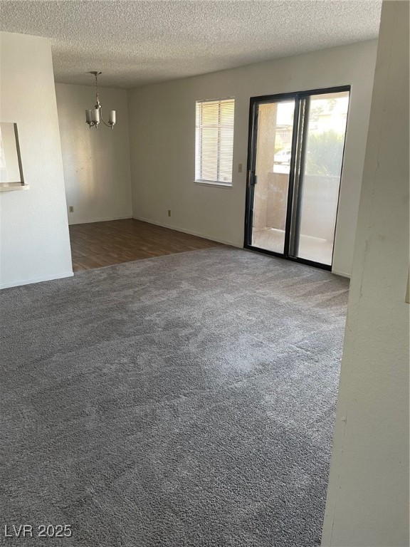3717 Snorkel Circle, Unit C Las Vegas, NV 89108 - Photo 4 of 17 Spare room with dark carpet, a chandelier, and a textured ceiling