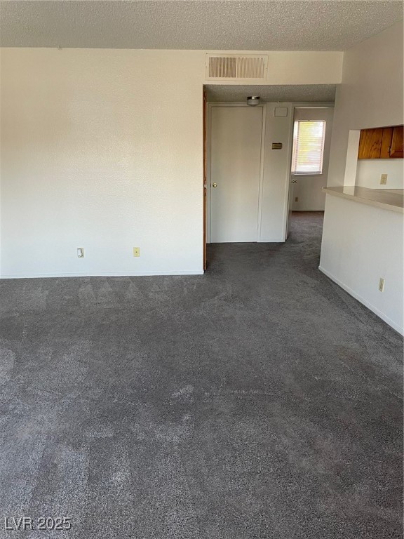 3717 Snorkel Circle, Unit C Las Vegas, NV 89108 - Photo 5 of 17 Spare room with dark colored carpet and a textured ceiling
