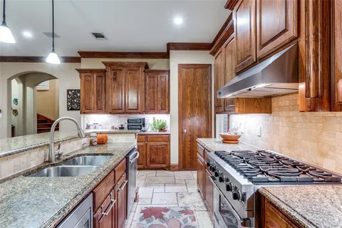 a kitchen with stainless steel appliances granite countertop stove a sink and a refrigerator