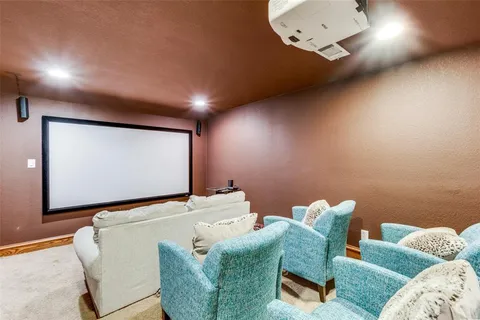 a view of a livingroom with wooden floor a ceiling fan and windows