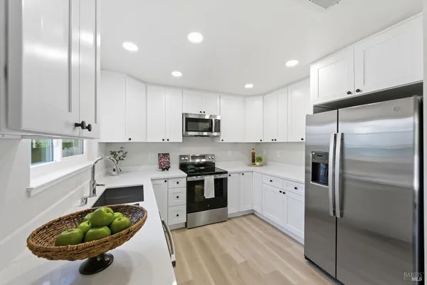 a kitchen with stainless steel appliances granite countertop a refrigerator sink and cabinets