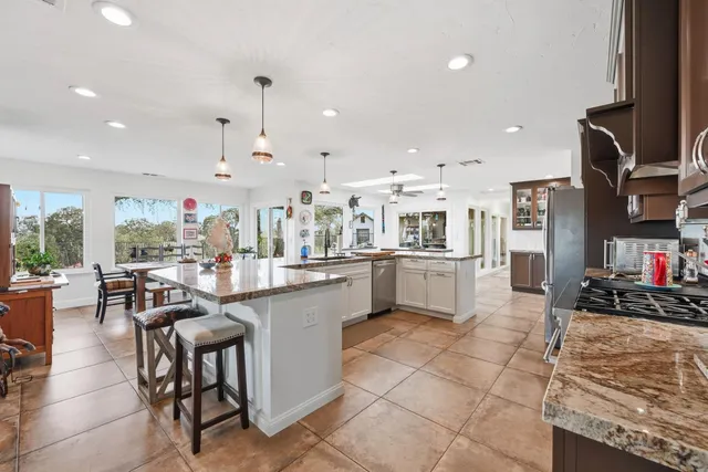 a kitchen with stainless steel appliances kitchen island granite countertop a sink and cabinets