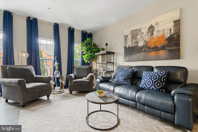 a living room with furniture potted plant and a large window