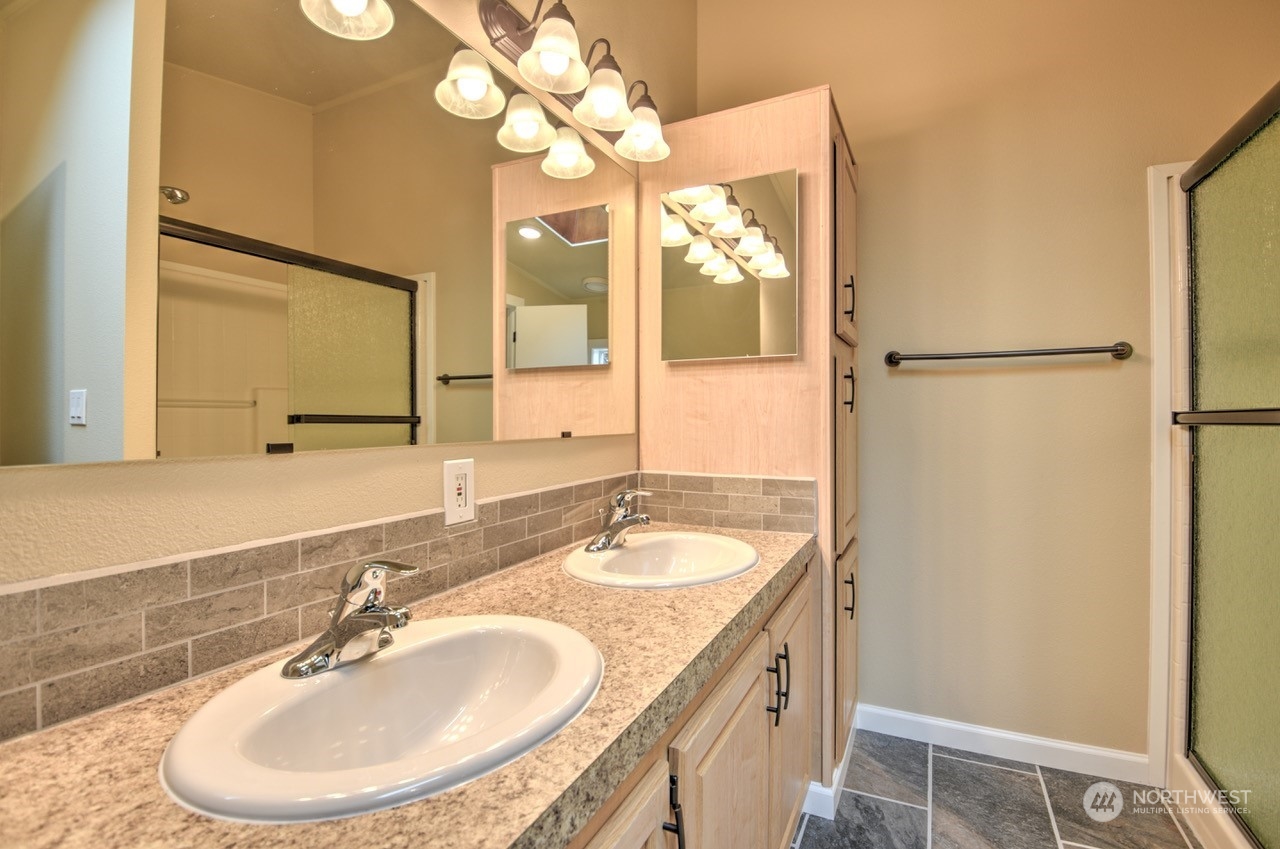 19212 Old Ranch Lane Southwest Rochester, WA 98579 - Photo 18 of 33 a bathroom with a granite countertop sink a mirror and a shower
