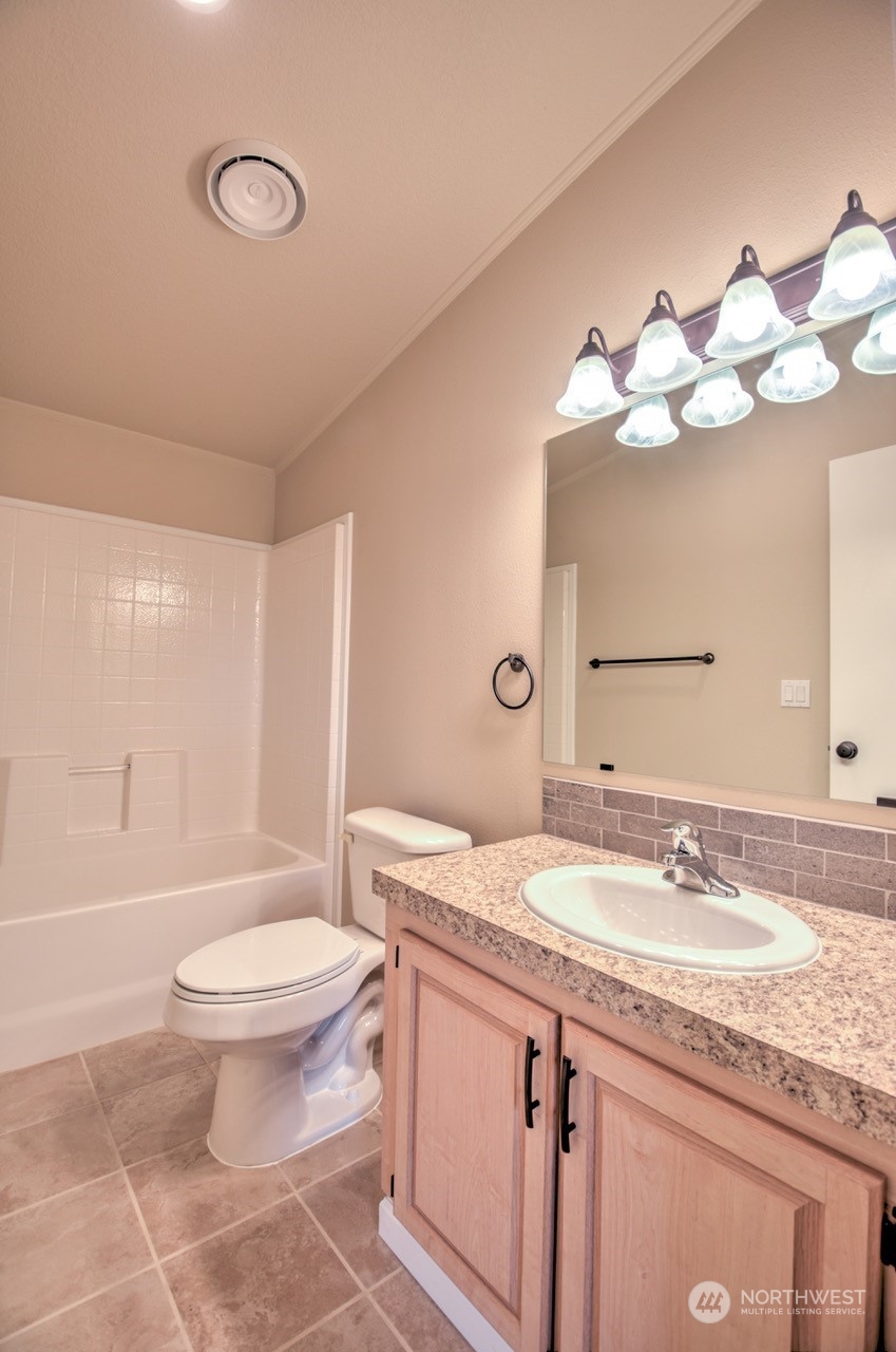19212 Old Ranch Lane Southwest Rochester, WA 98579 - Photo 21 of 33 a bathroom with a granite countertop sink a toilet and a mirror