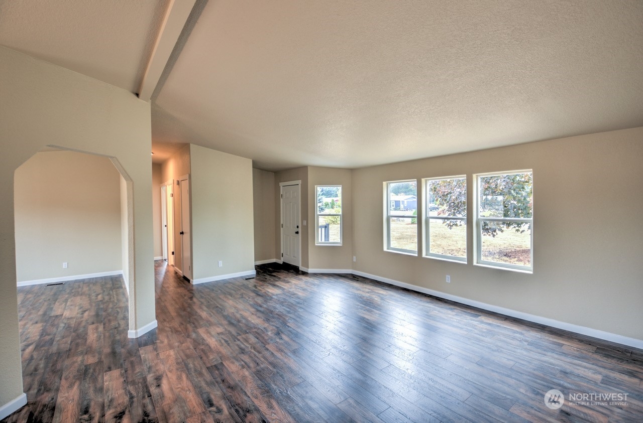19212 Old Ranch Lane Southwest Rochester, WA 98579 - Photo 6 of 33 an empty room with wooden floor and windows