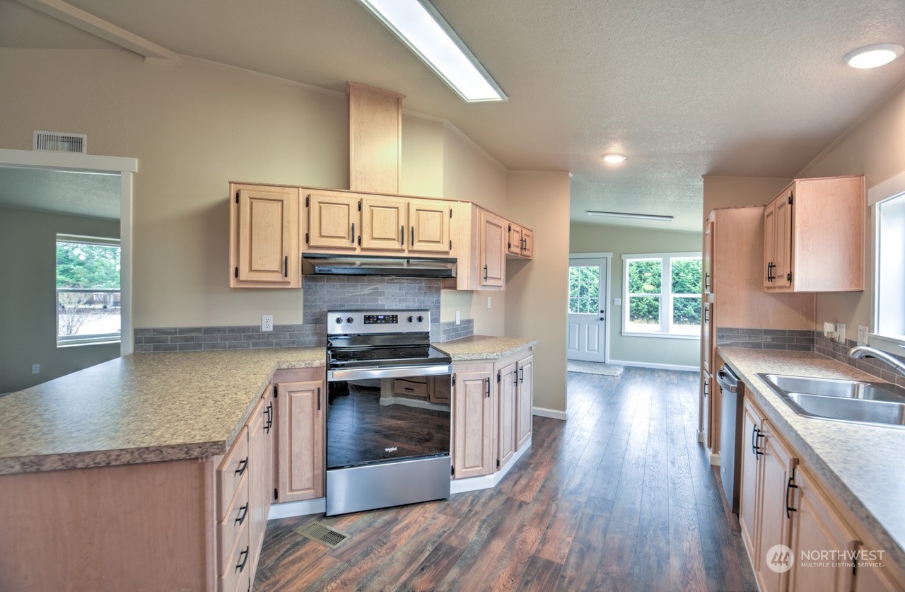 19212 Old Ranch Lane Southwest Rochester, WA 98579 - Photo 10 of 33 a kitchen with stainless steel appliances granite countertop a stove a sink and a refrigerator