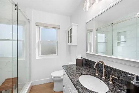 a bathroom with a granite countertop toilet sink and mirror