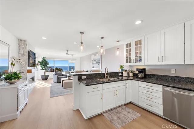 a kitchen with granite countertop a sink stainless steel appliances and cabinets