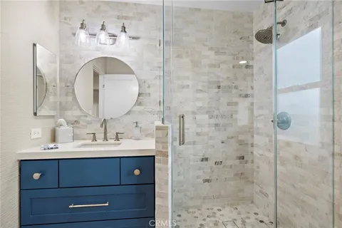 a bathroom with a sink a mirror and shower